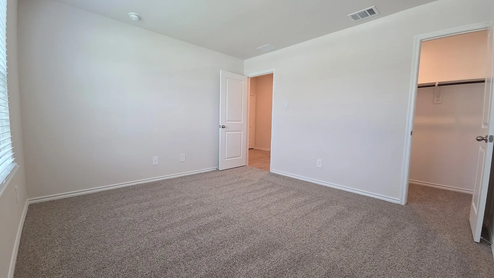 Carpeted interior space with white walls and baseboards