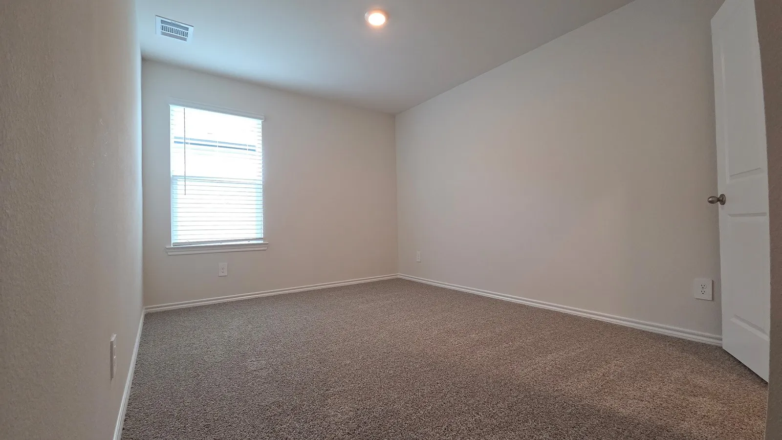 Carpeted room featuring a single window with blinds, recessed lighting, and a neutral wall color