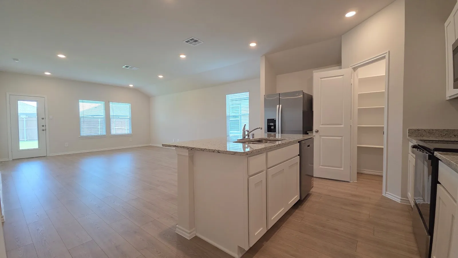 Kitchen island with an undermount sink, stainless steel dishwasher, and granite countertop