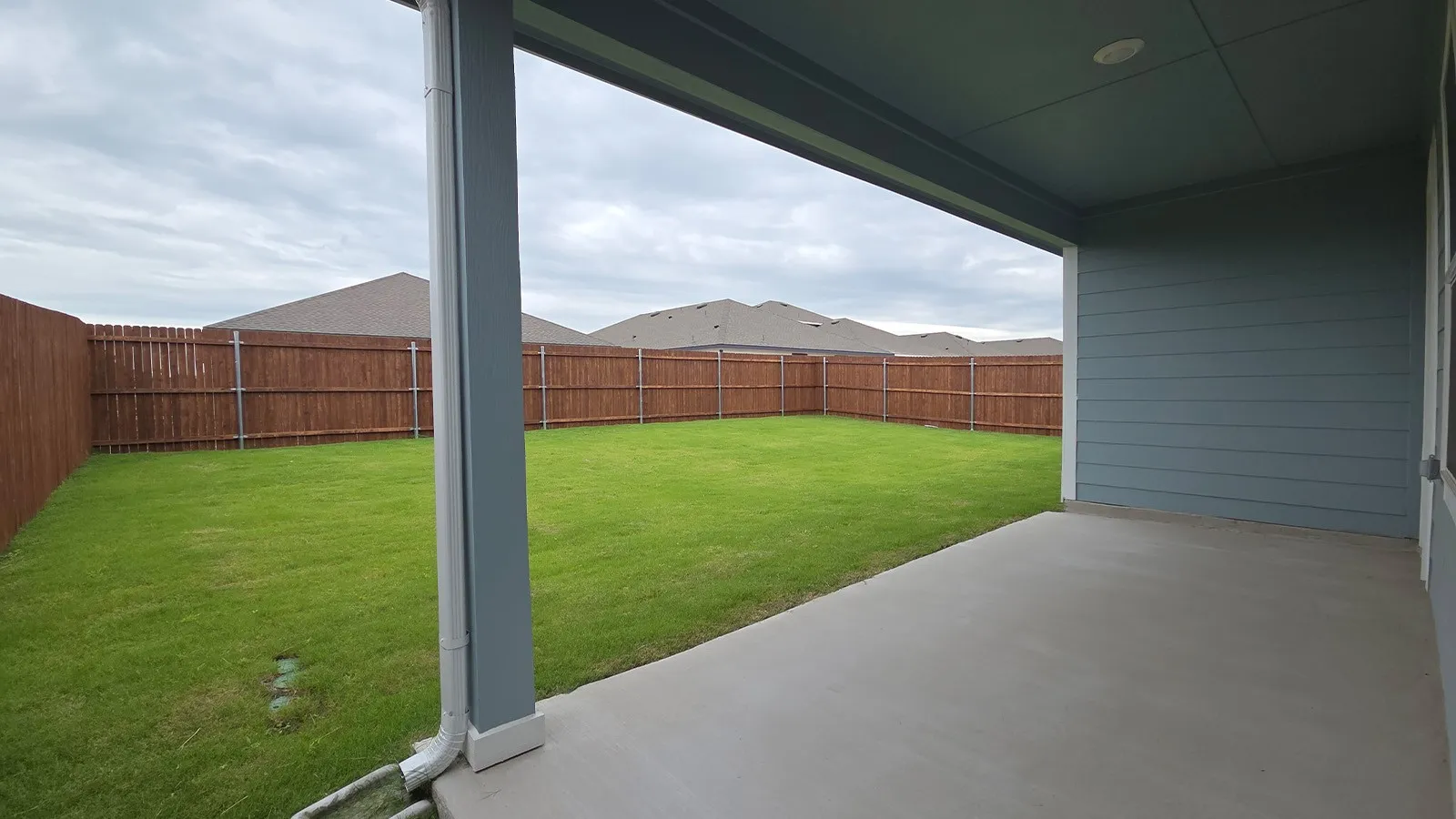 Covered patio with a concrete surface, providing exterior living space