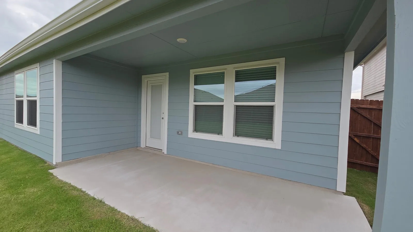 Covered patio featuring a concrete slab, recessed lighting, and a white framed glass door