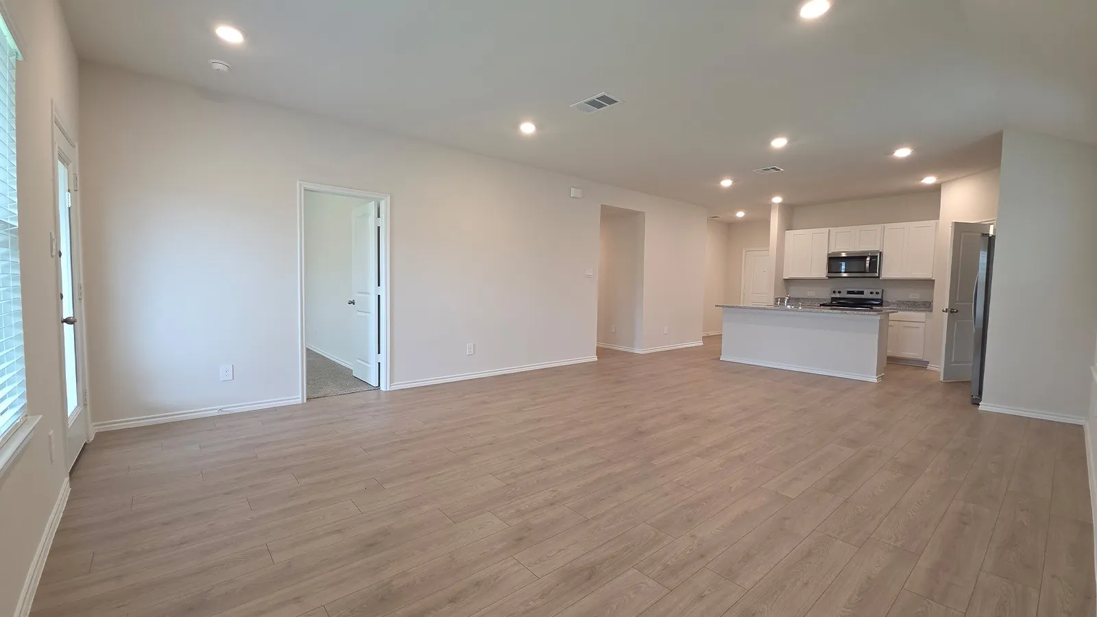 Open-concept interior featuring wood-finish flooring, recessed lighting, and light-toned walls