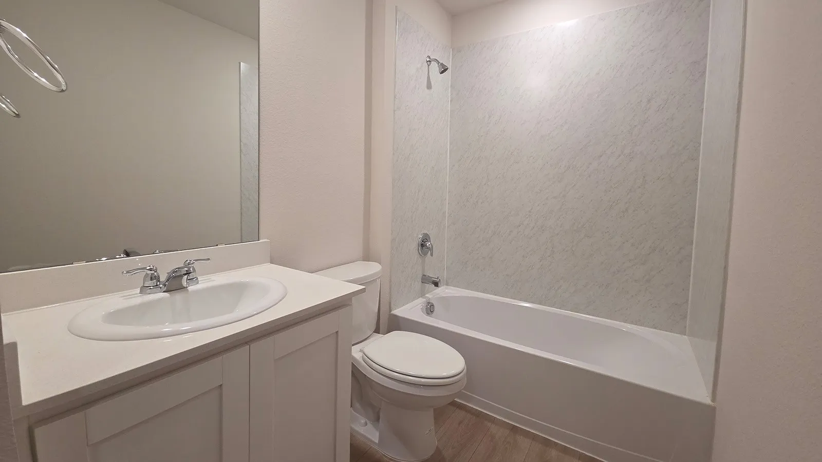White vanity with integrated sink, chrome fixtures, and a large mirror