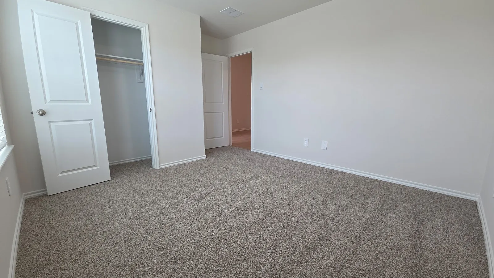 Carpeted interior space featuring light neutral wall paint