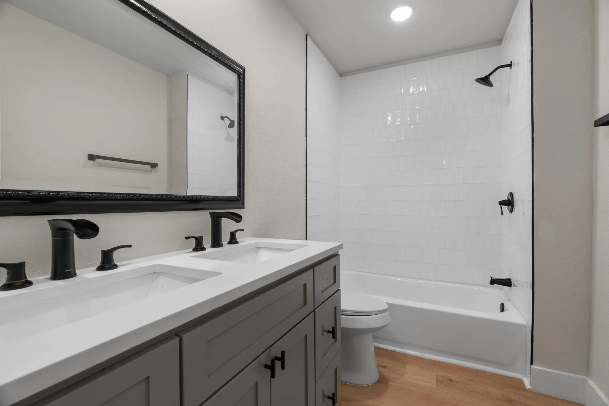 Bathroom with a double vanity featuring a light gray cabinet and white countertop