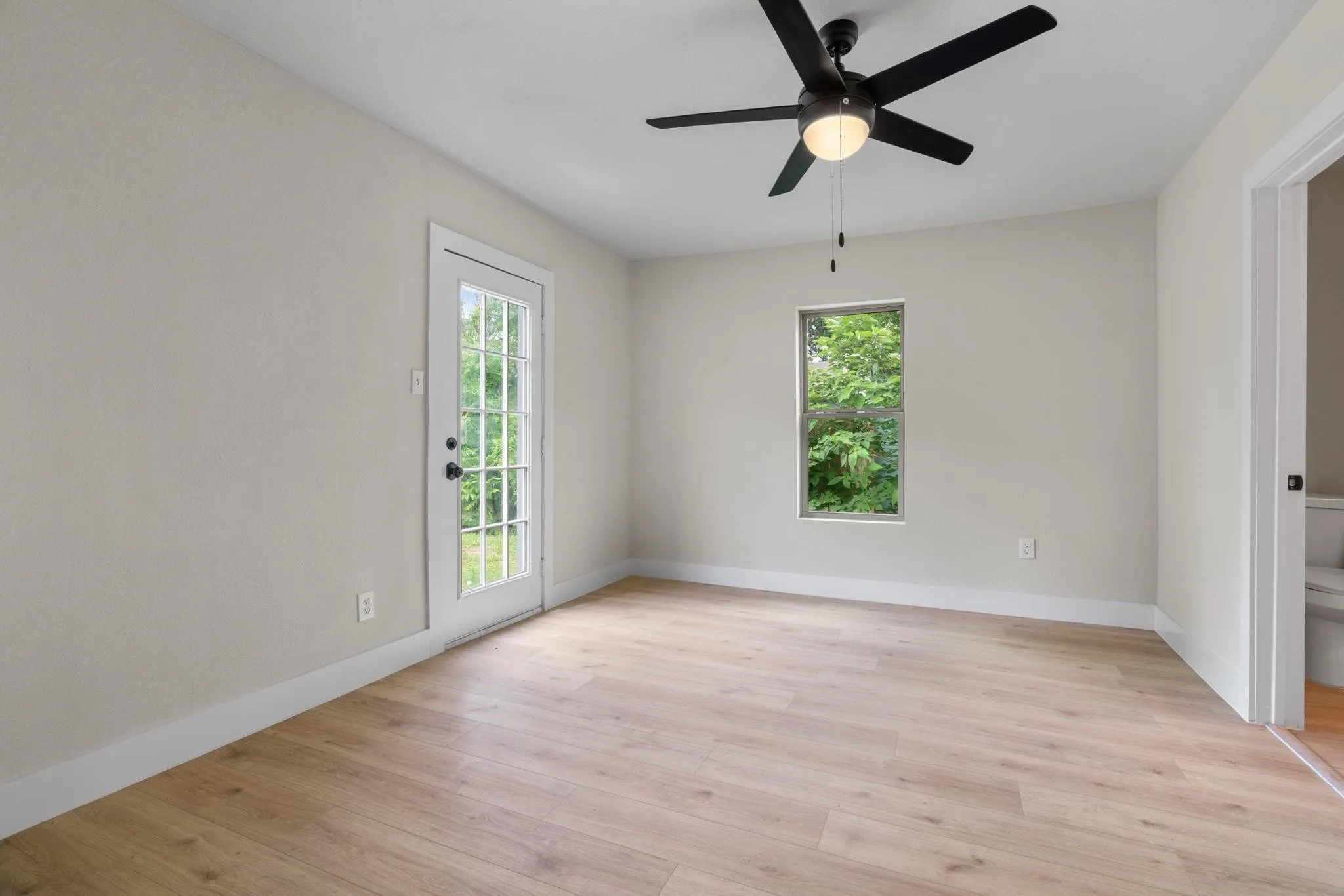 Unfurnished room with light wood-style flooring, ceiling fan, and baseboards