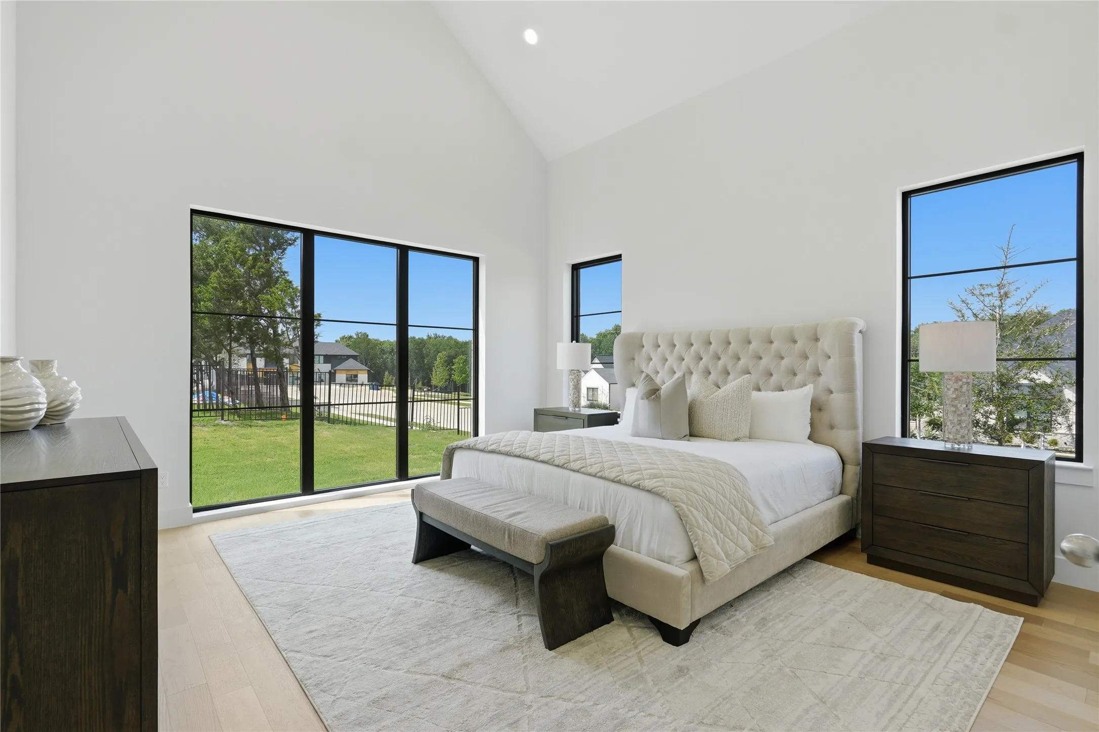 Room featuring a vaulted ceiling, light wood-finish flooring, and bright white walls