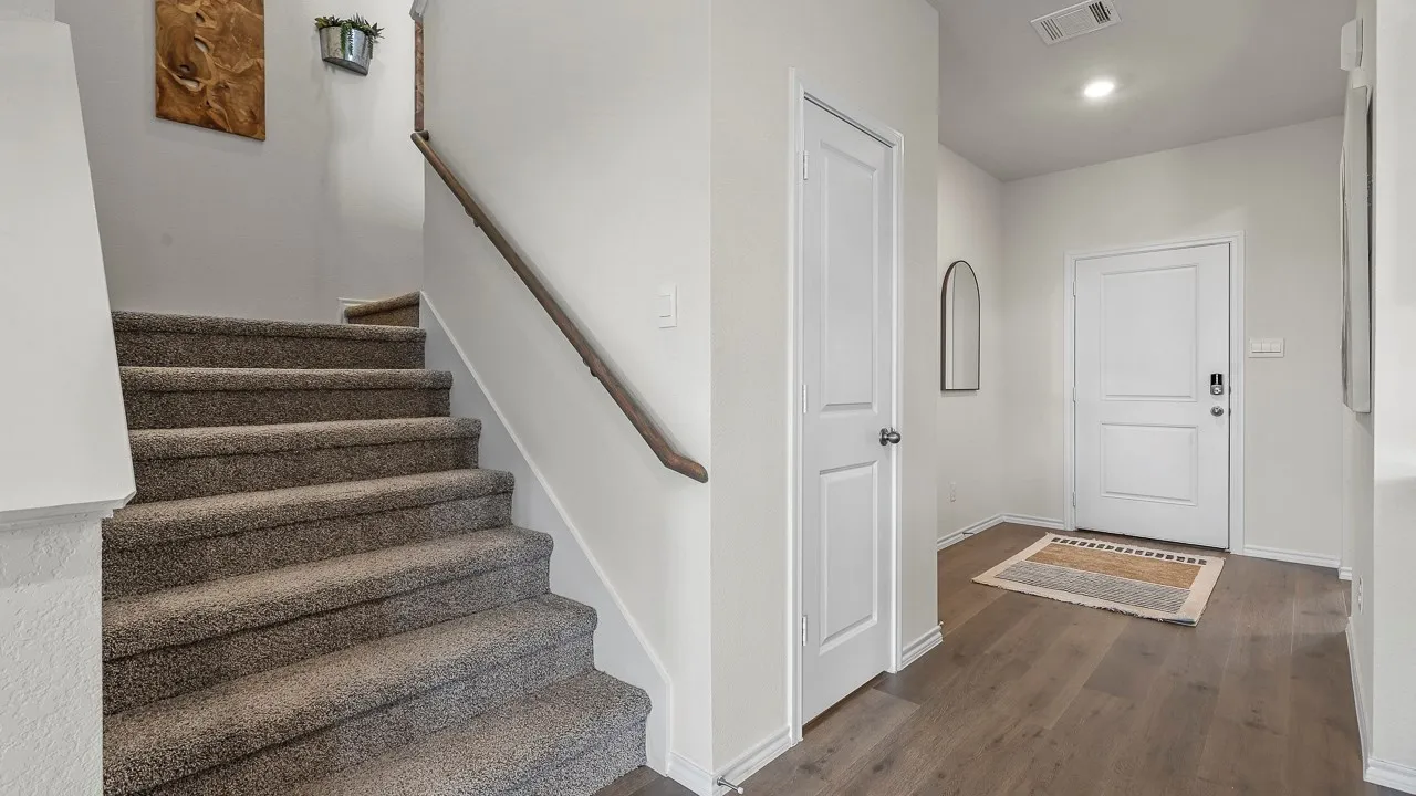 Entryway featuring wood-finish flooring and a white front door with panel detailing