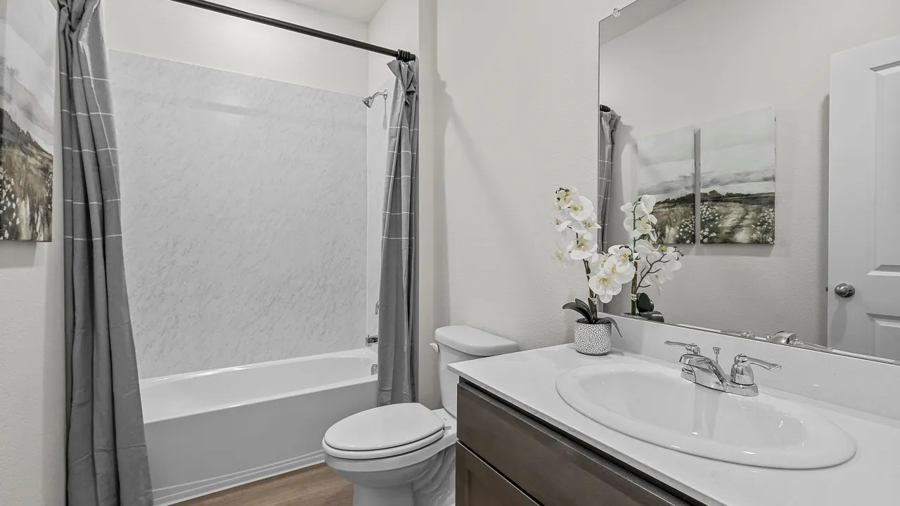 Full bathroom featuring a white tub and shower combination with a textured surround