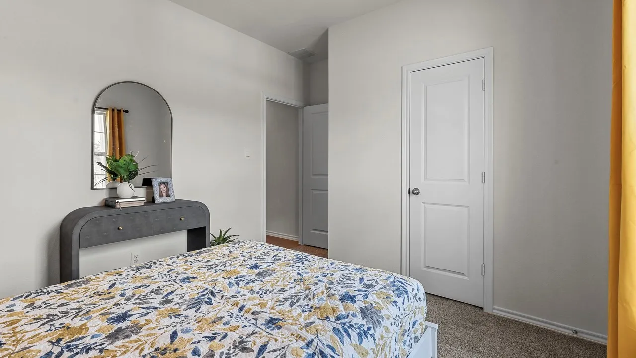 Neutral wall paint, framed window with visible blinds, white two-panel interior door, and carpet flooring
