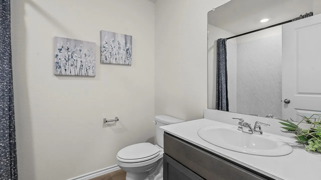 Bathroom vanity with a white countertop and integrated sink, chrome faucet, and rectangular mirror