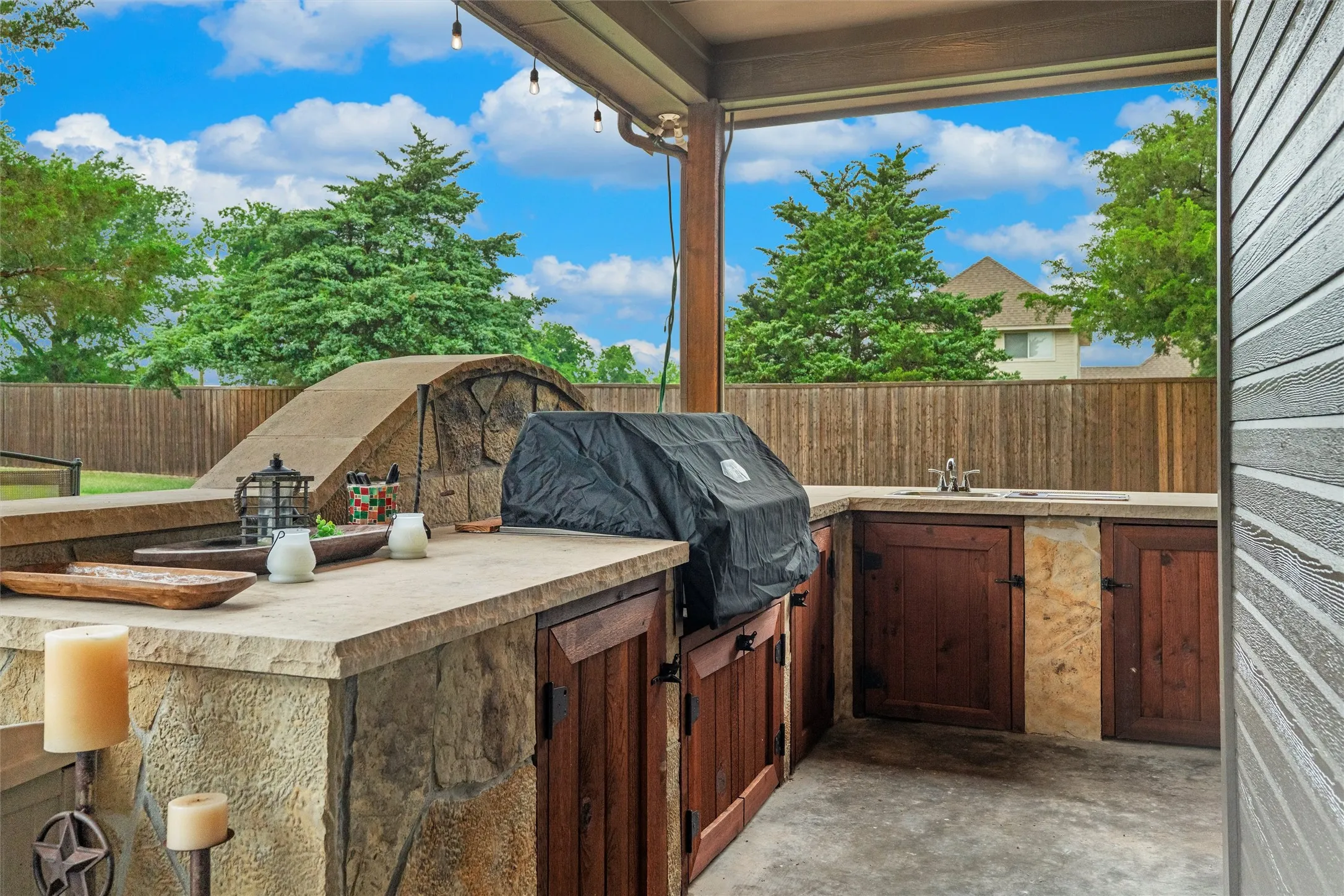 Out door kitchen area with a grill, storage, place to sit and a place to serve