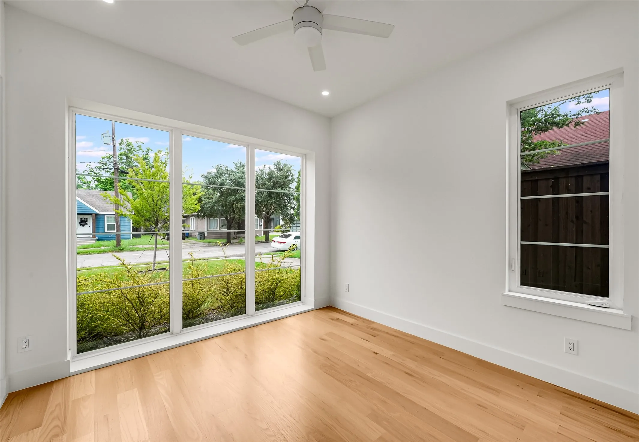 Bright interior space featuring wood-finish flooring, recessed lighting, and a ceiling fan