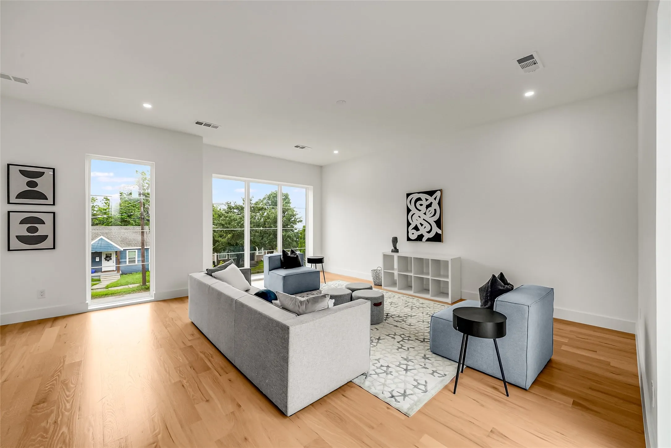 Bright living area featuring wood-finish flooring and recessed ceiling lighting