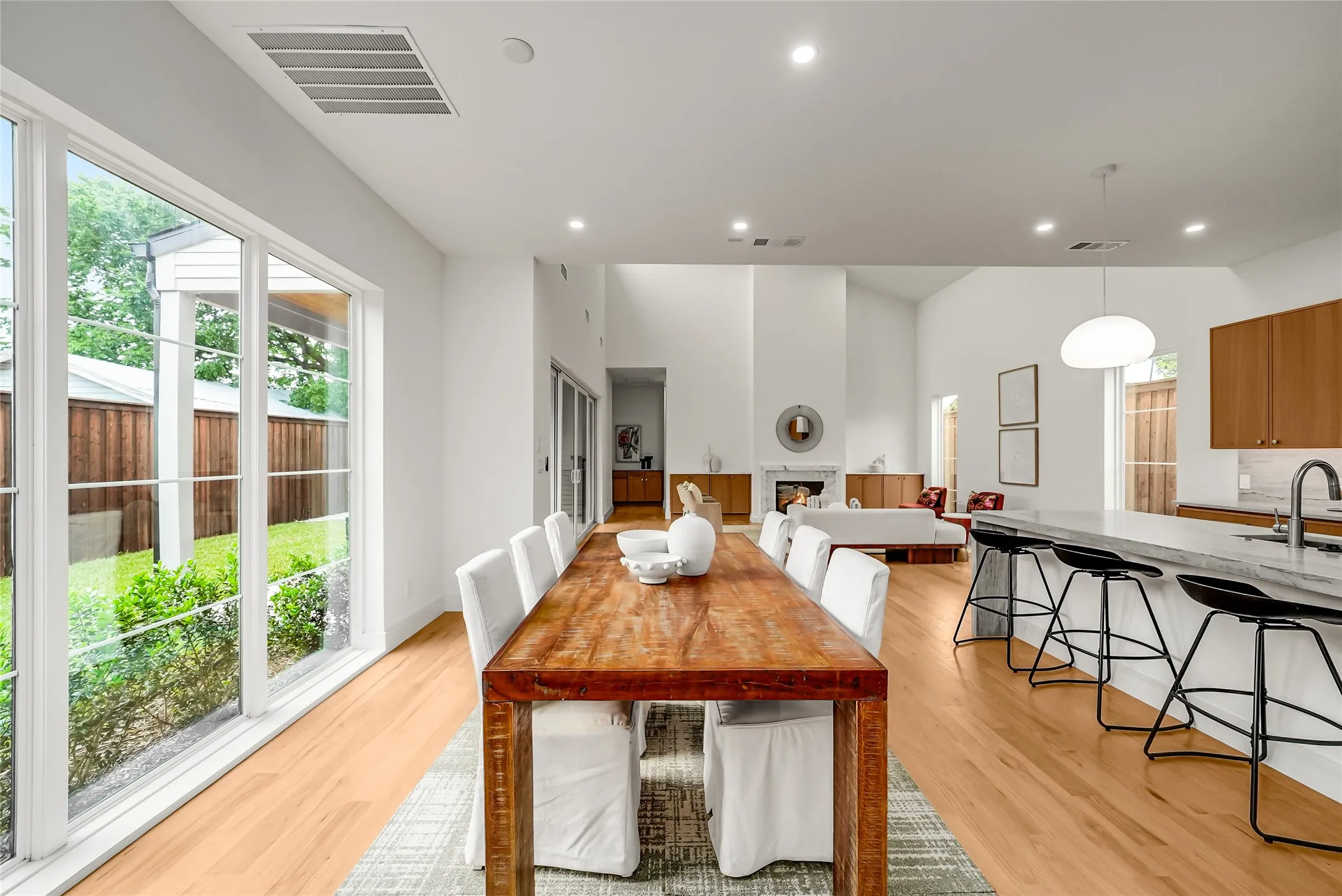 Open-concept interior featuring light wood-finish flooring, a vaulted ceiling, and a kitchen island with seating