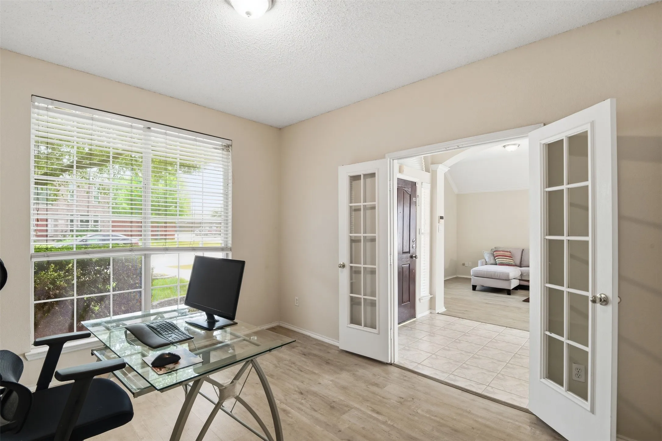 Office with view of front lawn and living room across the foyer.