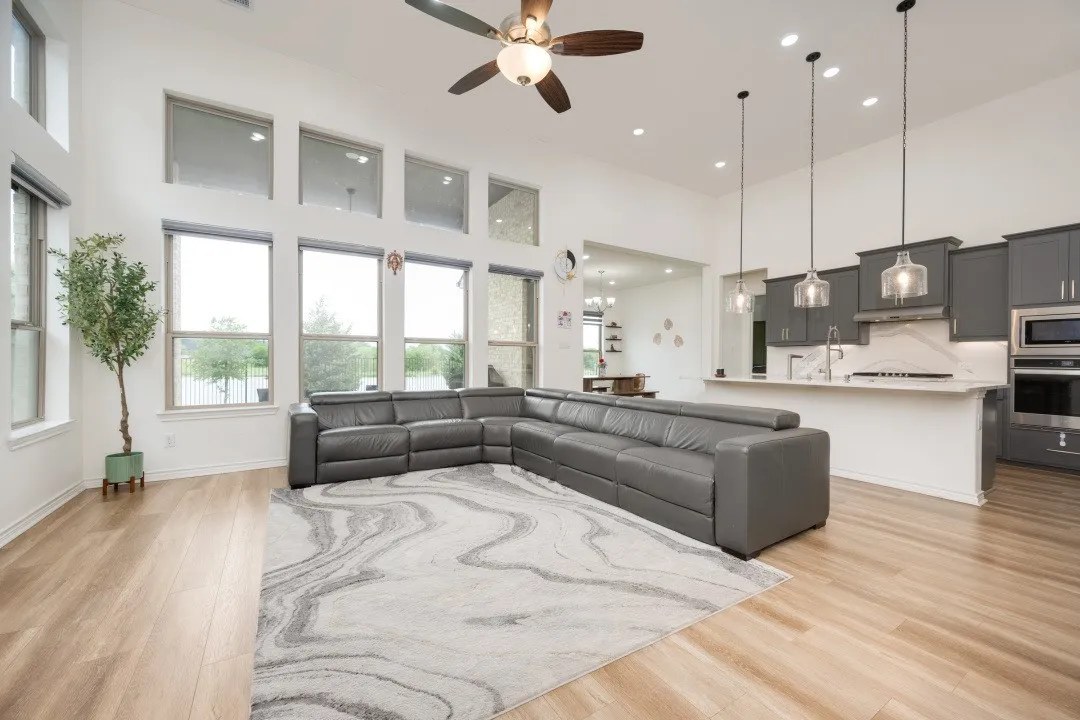 Spacious open-concept interior featuring light wood-finish flooring and high ceilings