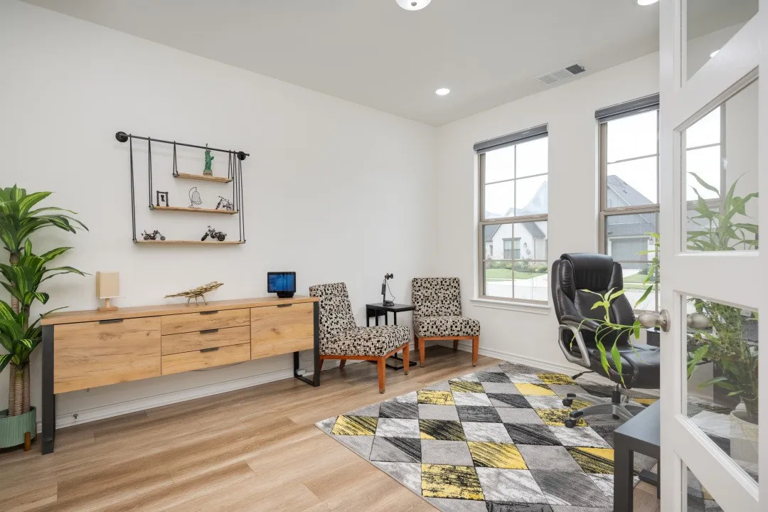 Bright room with two large windows, wood-finish flooring, a built-in wall shelf, and recessed lighting