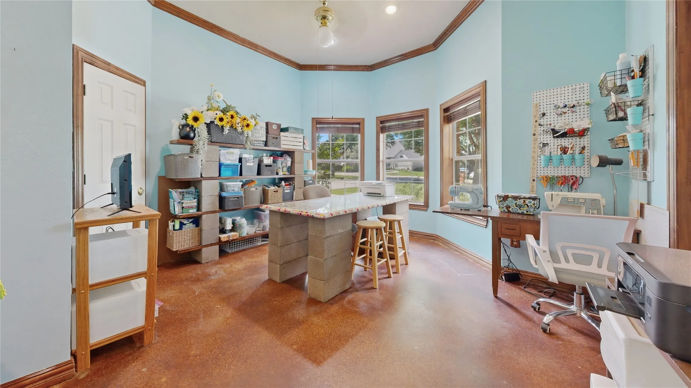 Versatile room featuring multiple windows, a ceiling fan, wood-finish flooring, and light blue walls
