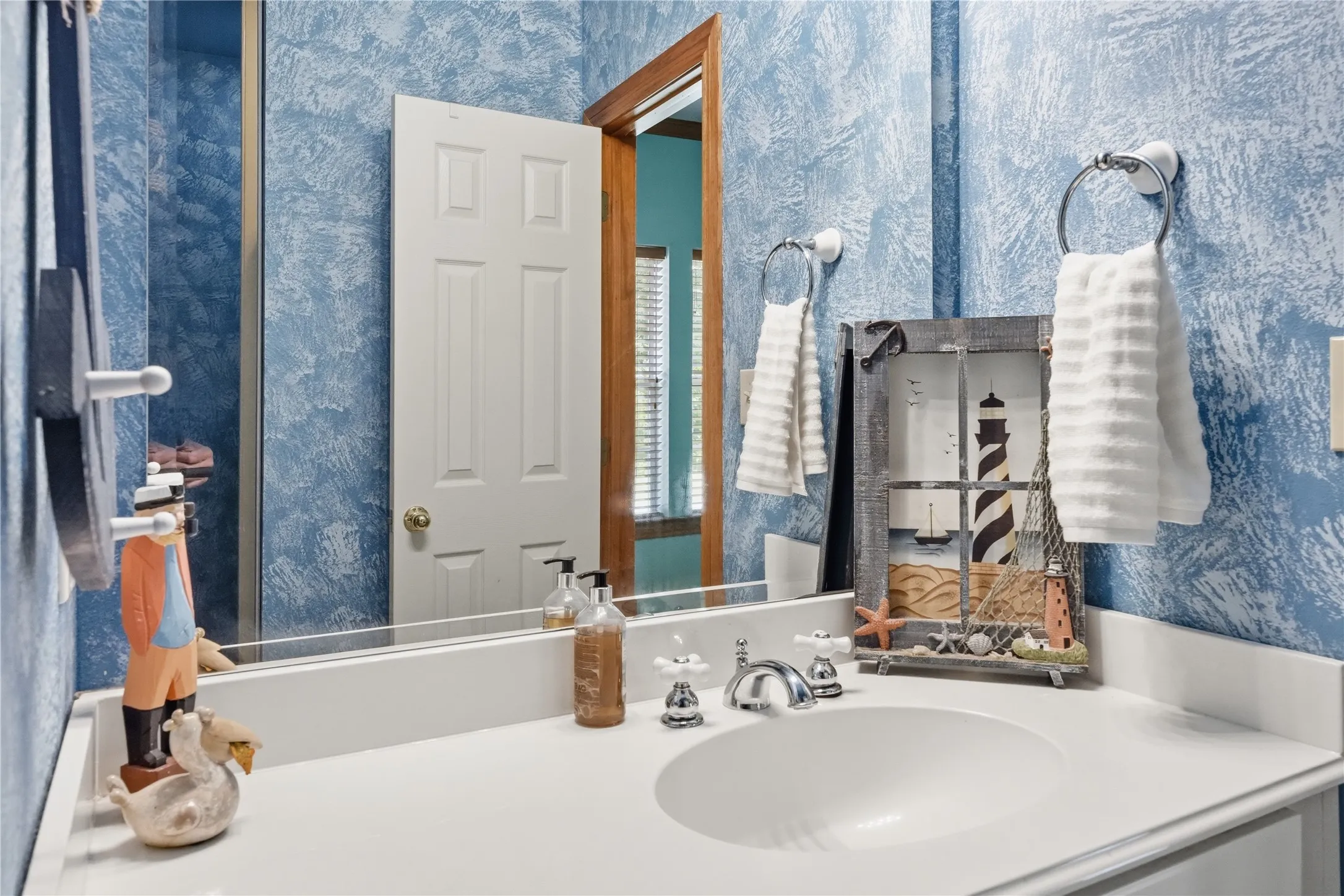 Bathroom vanity featuring an integrated sink, polished chrome fixtures, and a white solid surface countertop