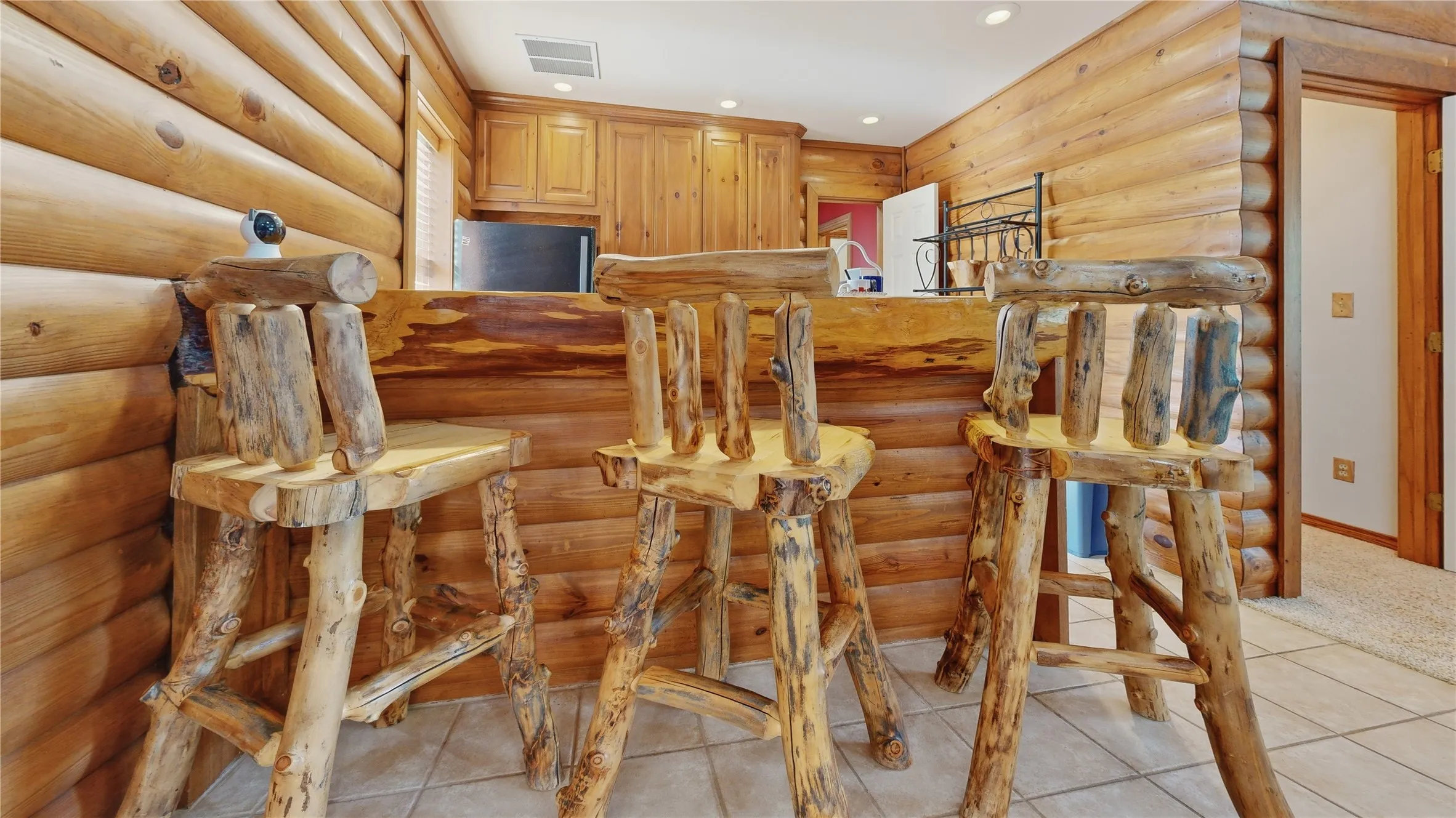 Log cabin-style interior with natural wood walls and a built-in bar