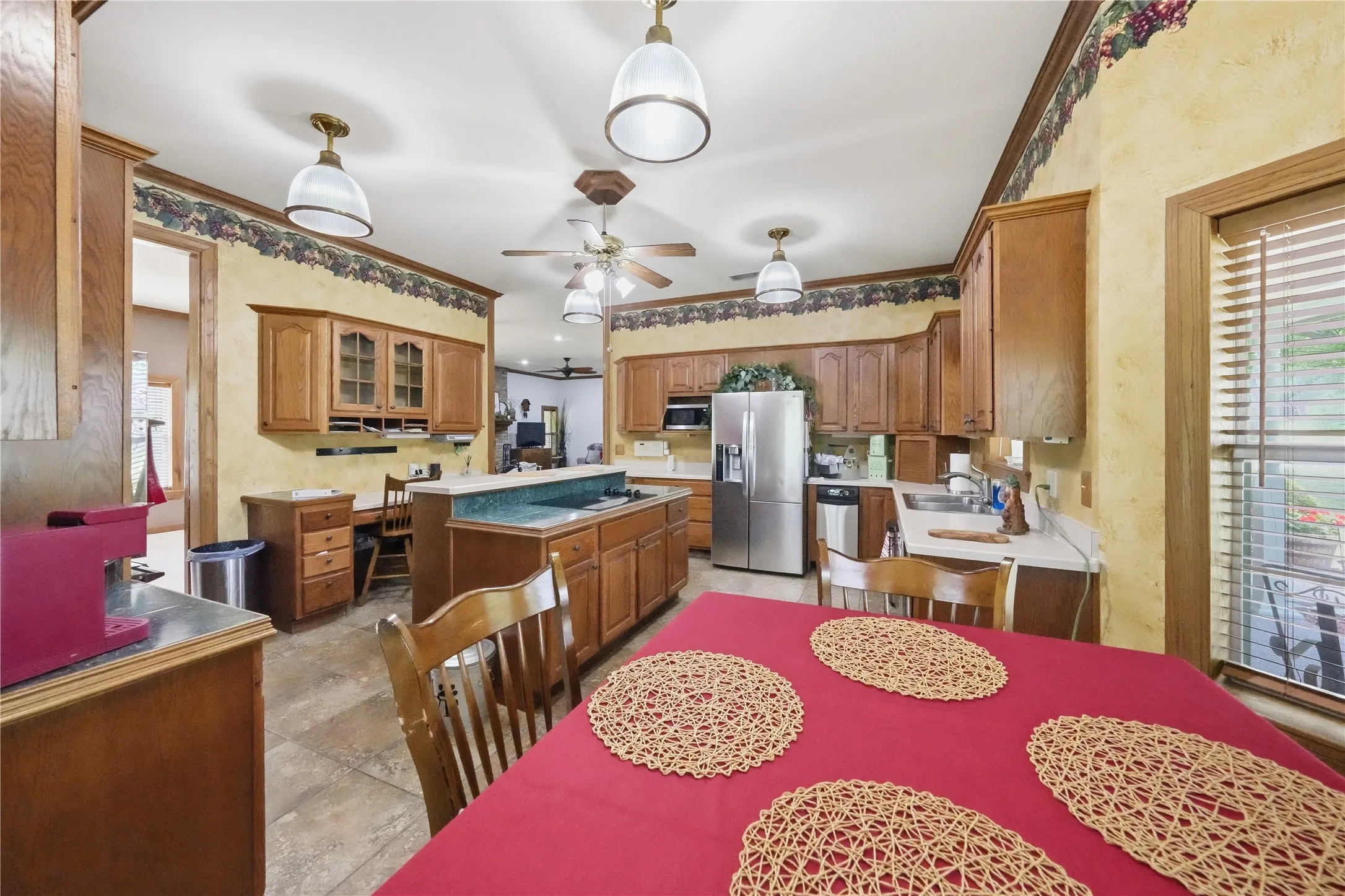 Kitchen featuring wood cabinetry, stainless steel refrigerator, recessed lighting, and a center island with a breakfast bar