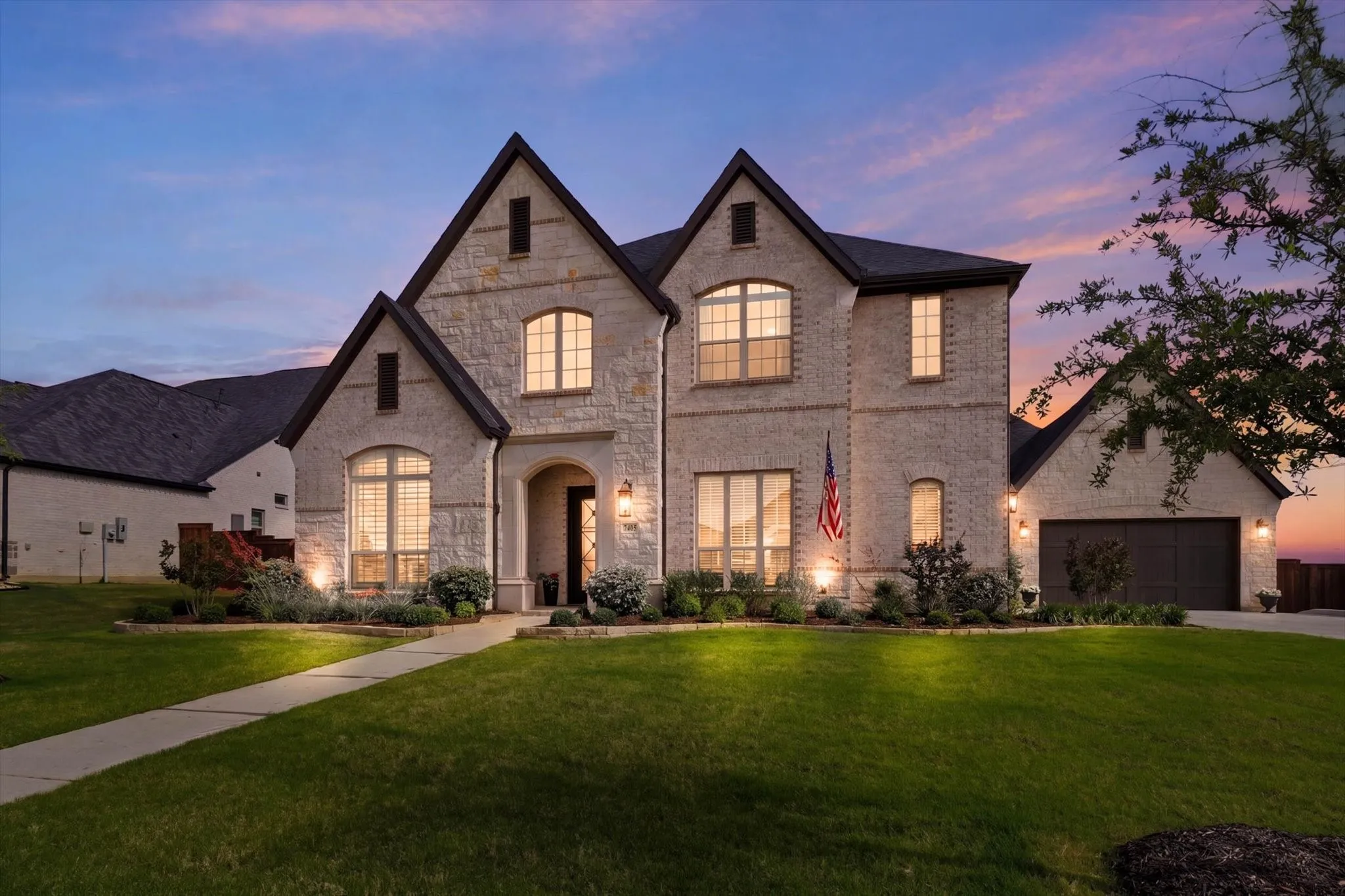 Stunning stone and brick exterior with contrasting dark trim and a dark roof