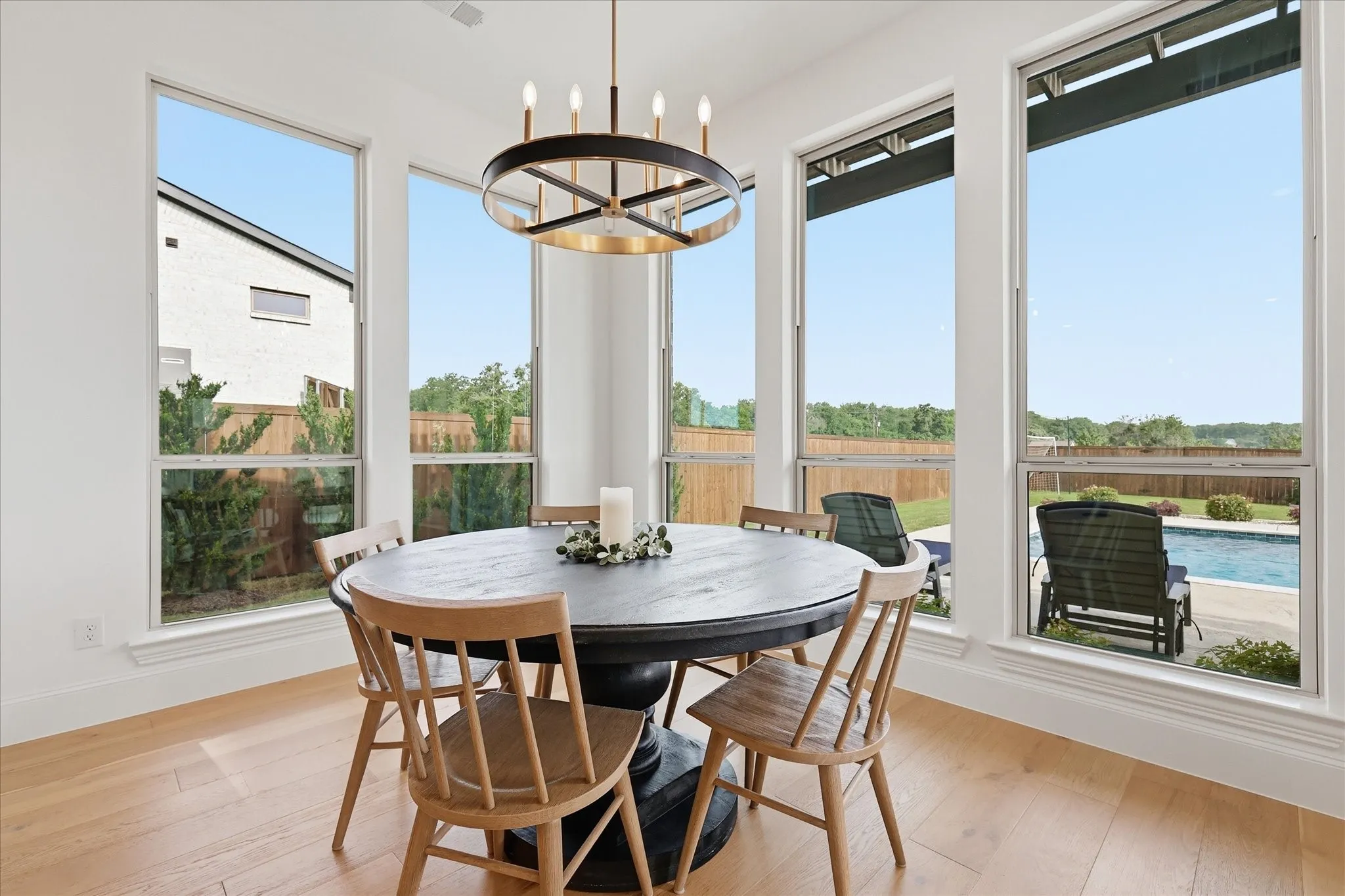 Dining area with light wood-finish flooring and a contemporary chandelier