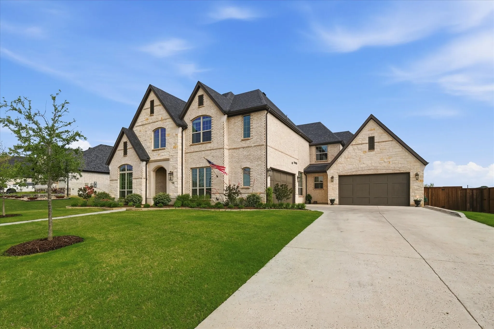 Stone and brick exterior with dark shingle roofing and gabled architectural details