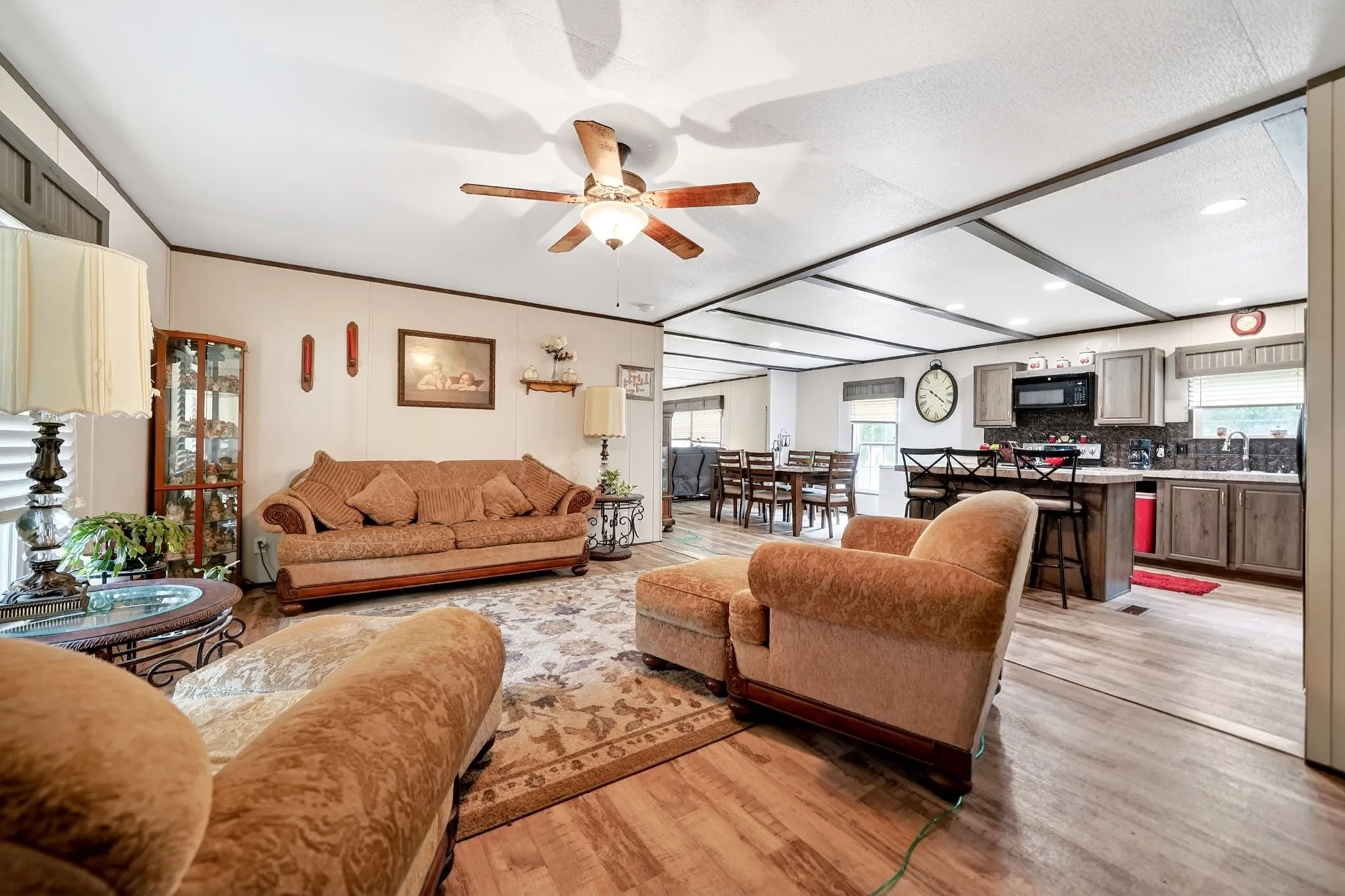 Open-concept living area featuring wood-finish flooring, a ceiling fan, and recessed lighting