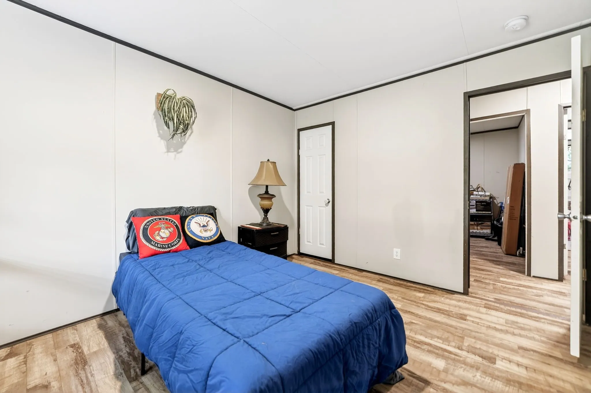 Room featuring wood-finish flooring, light-toned walls with dark trim, and a built-in closet with a white panel door