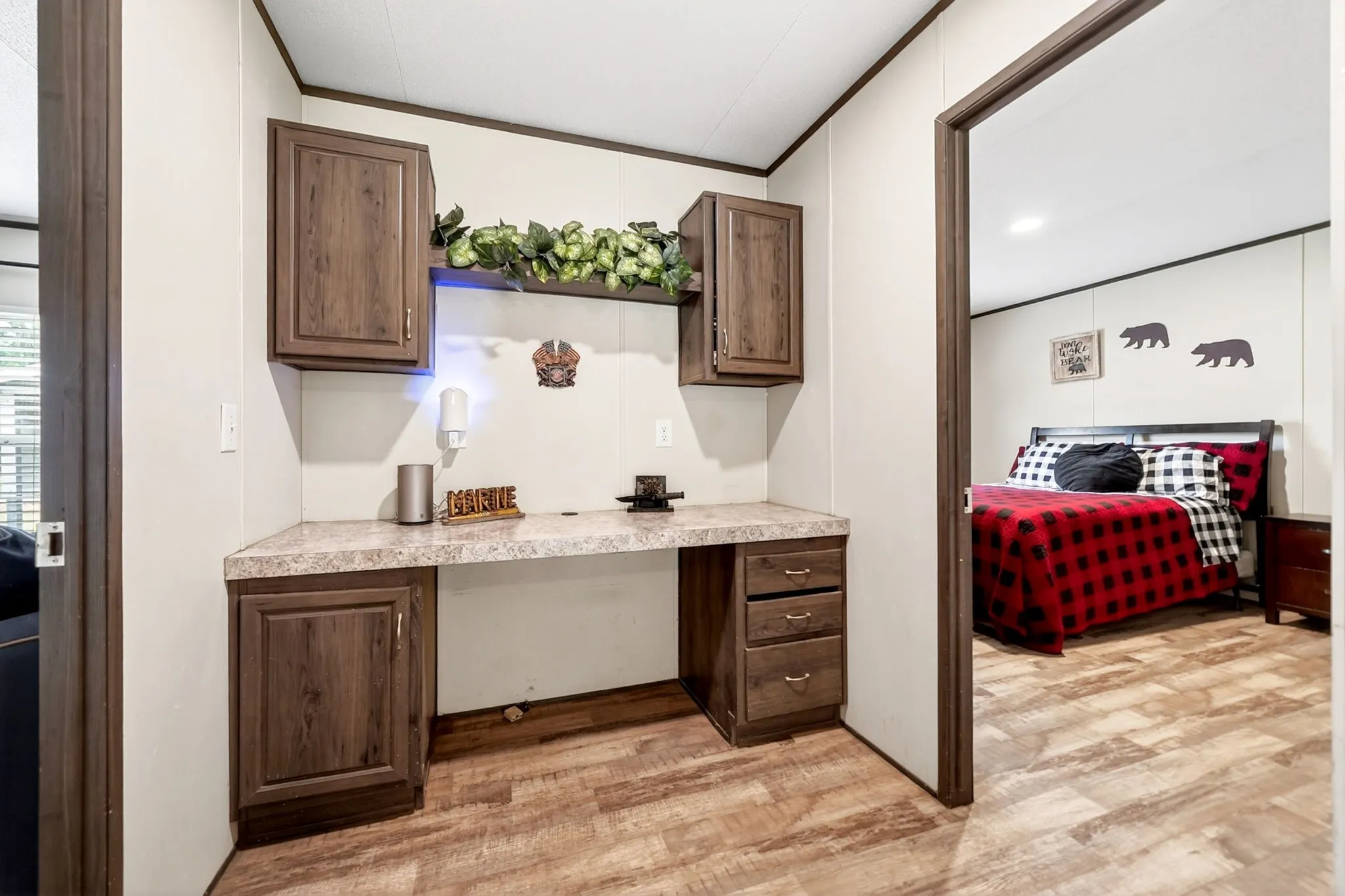 Built-in desk area featuring wood-finish cabinetry, a light-colored countertop, overhead storage, and recessed lighting