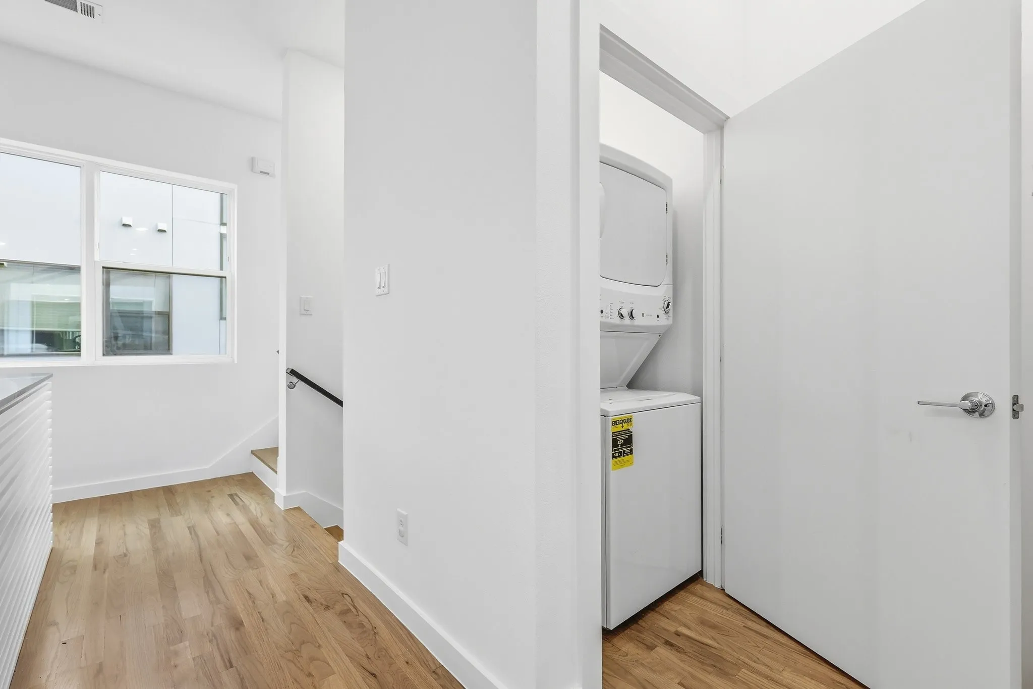 Integrated laundry area featuring a stacked washer and dryer