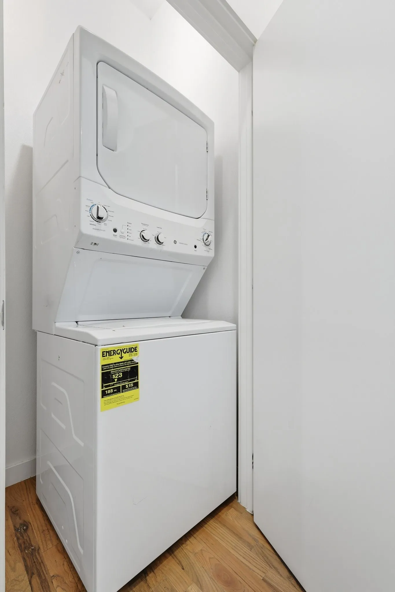 White stacked washer and dryer unit, featuring top-loading washer and front-loading dryer