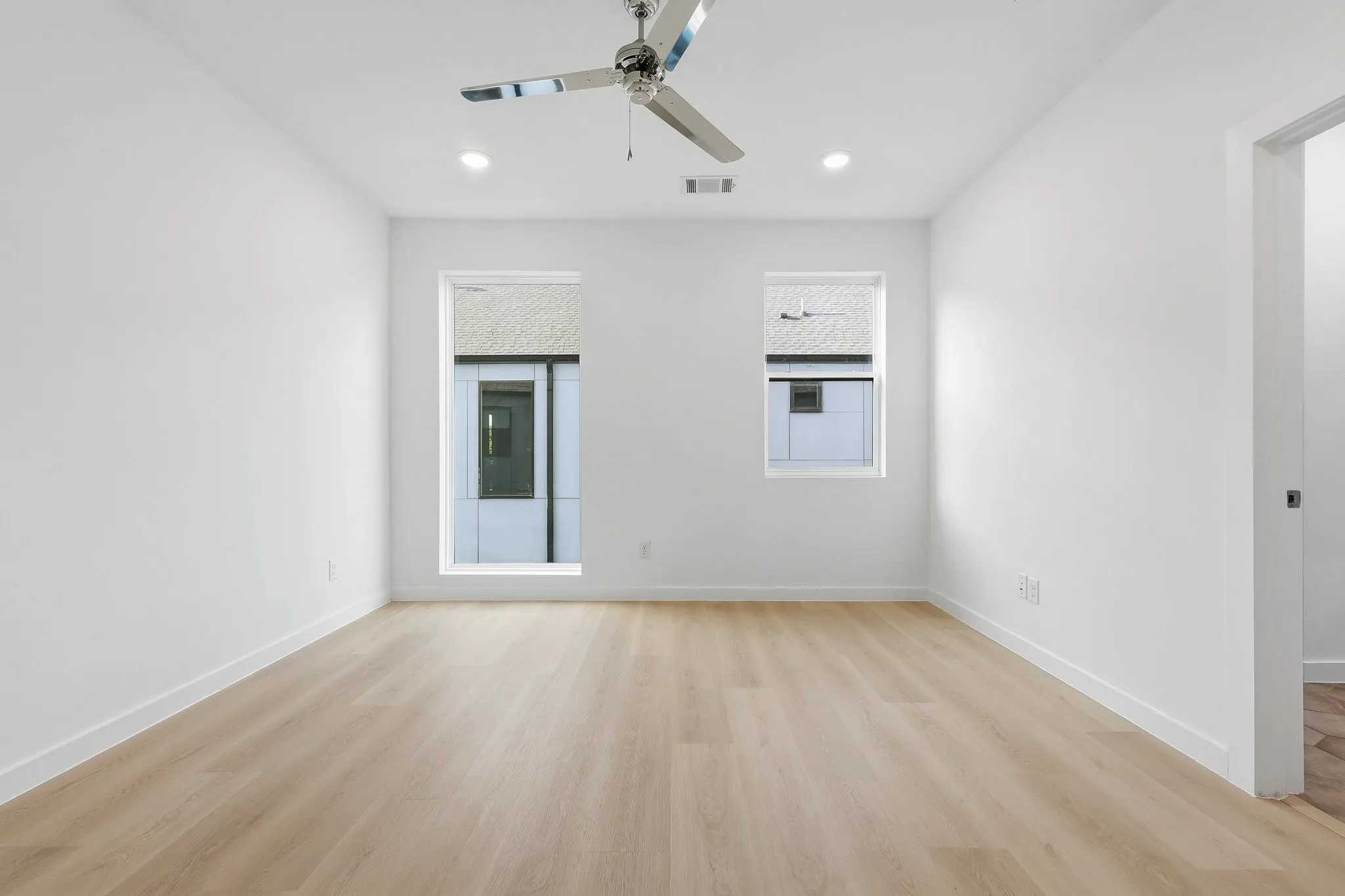 Light wood-finish flooring with white baseboards throughout