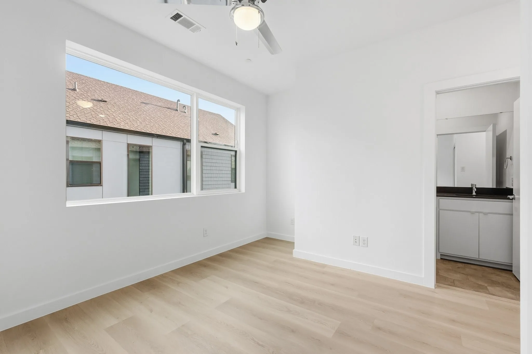 Light wood-finish flooring complemented by white baseboards and walls