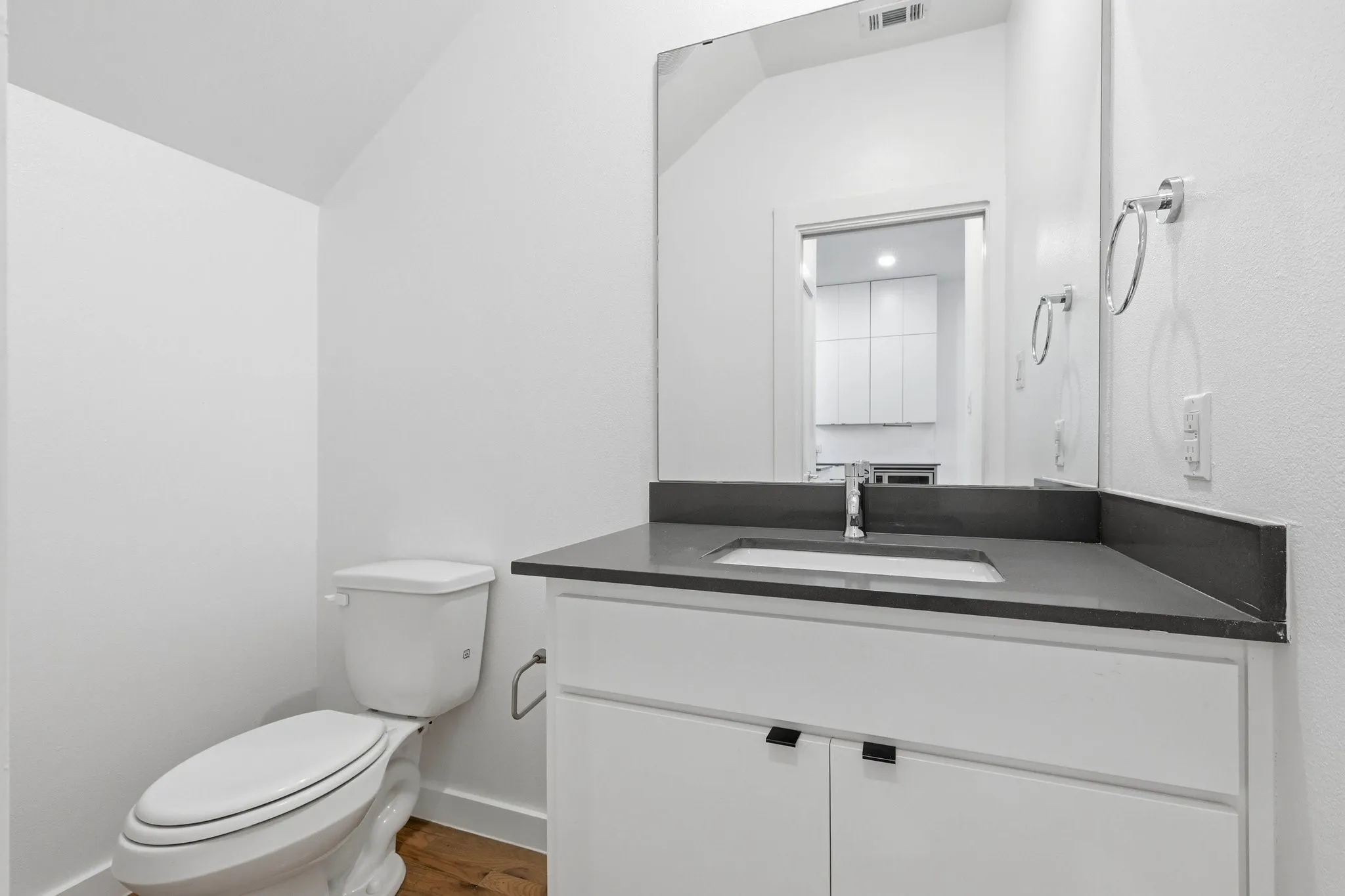 Bathroom featuring a white vanity with dark countertop, undermount sink, and chrome faucet