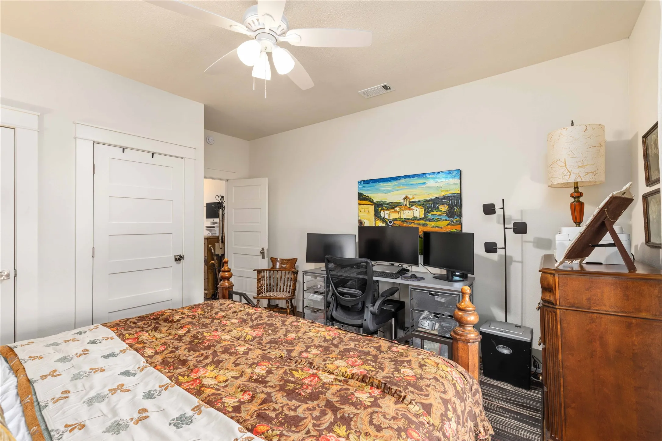 Bedroom featuring a ceiling fan, white paneled doors, and light-colored walls
