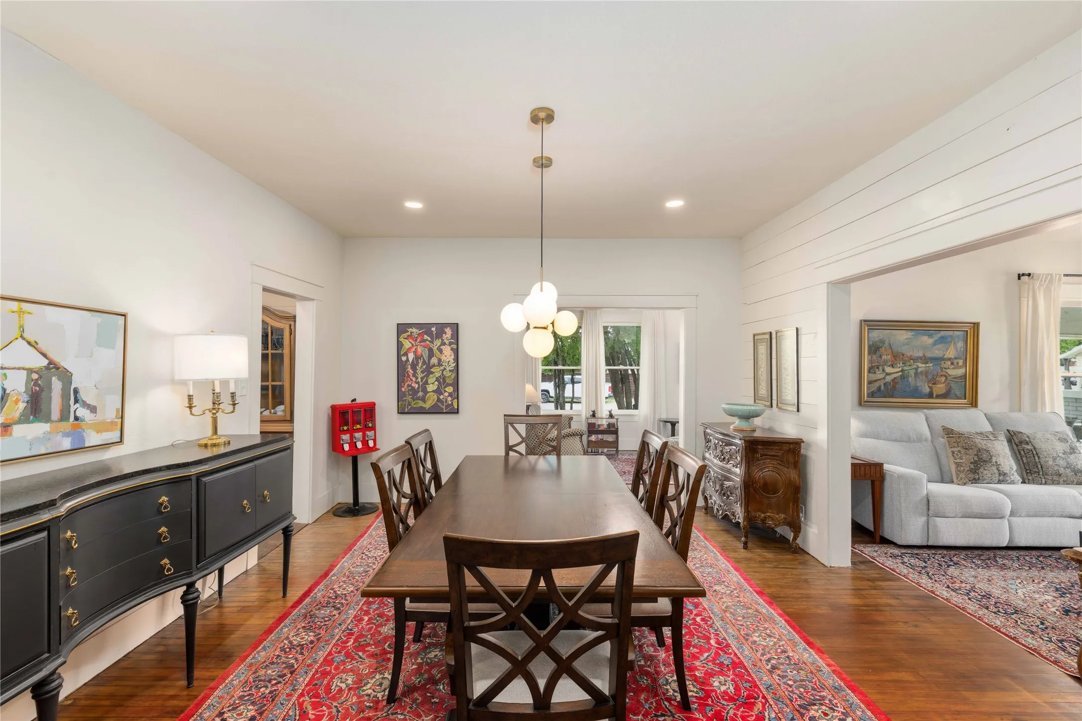 Hardwood-style flooring throughout, featuring an open-concept layout with white painted walls and a shiplap accent wall