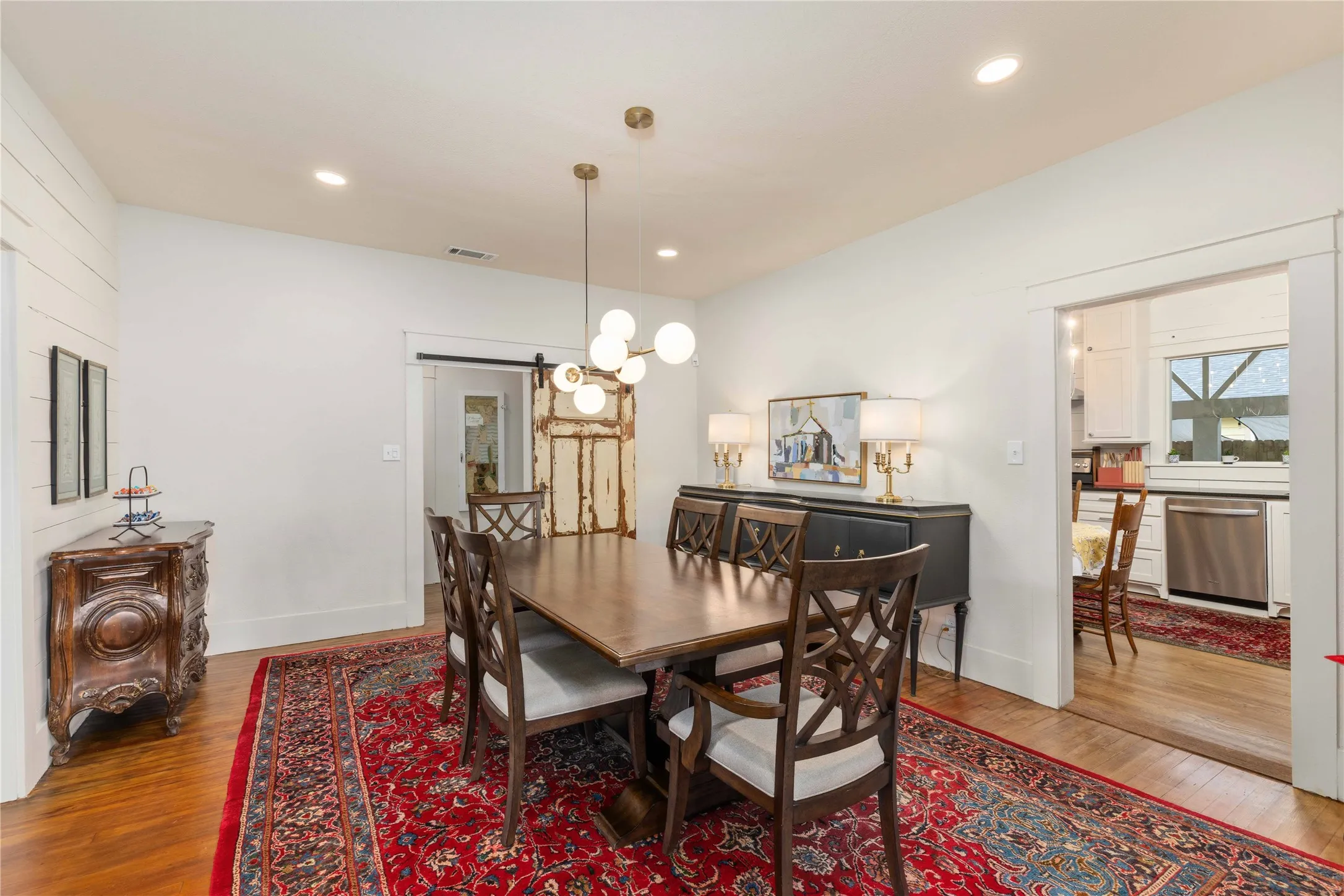 Dining area featuring a modern chandelier, recessed lighting, and wood-finish flooring