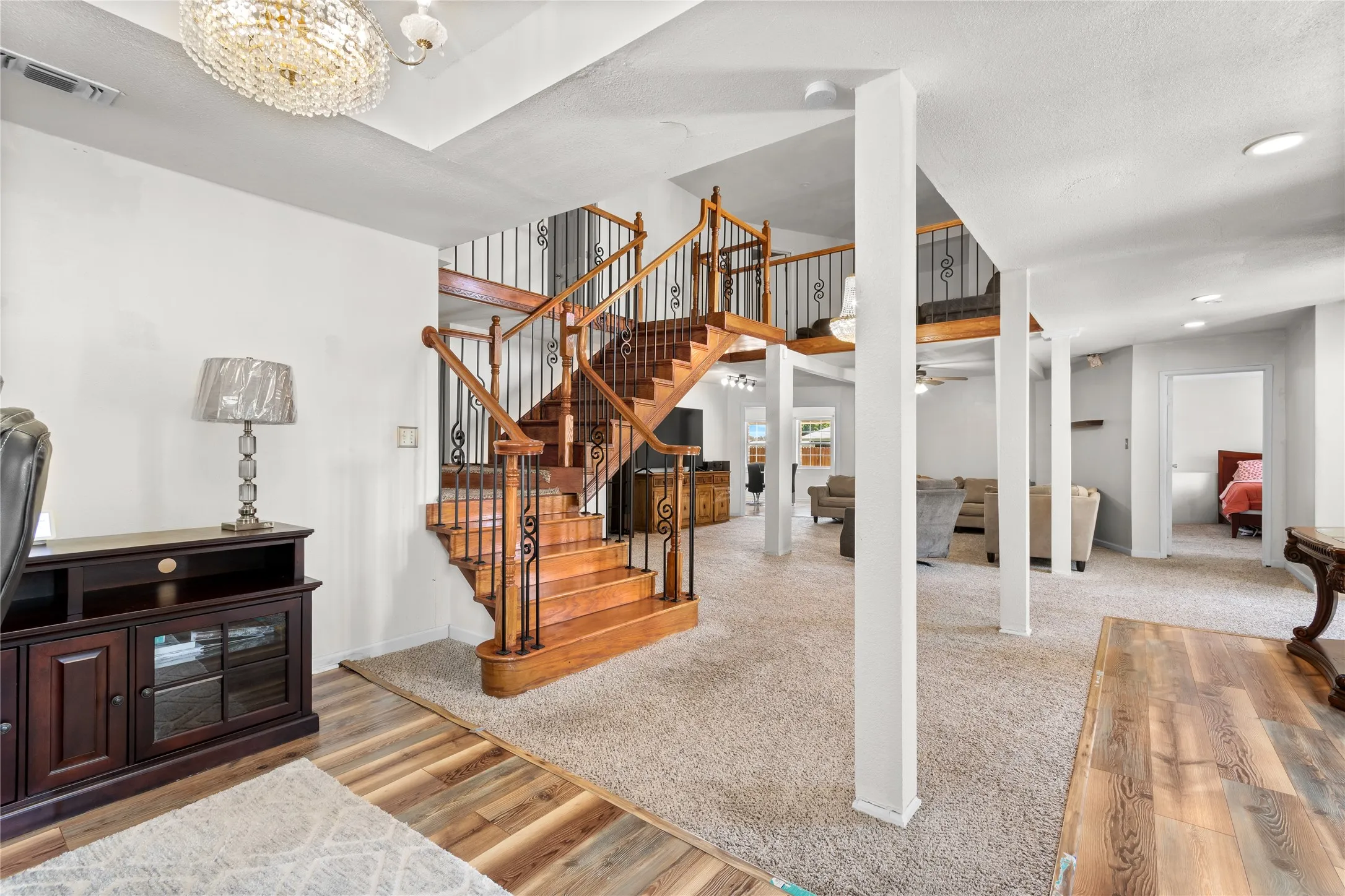 Grand staircase featuring wood treads and wrought iron balusters