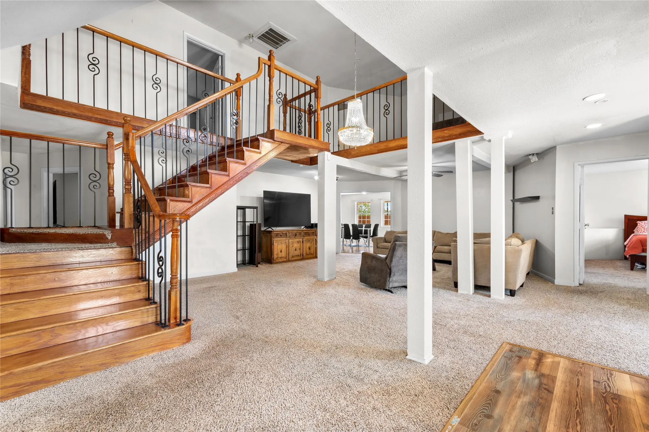 Grand wooden staircase with wrought iron balusters