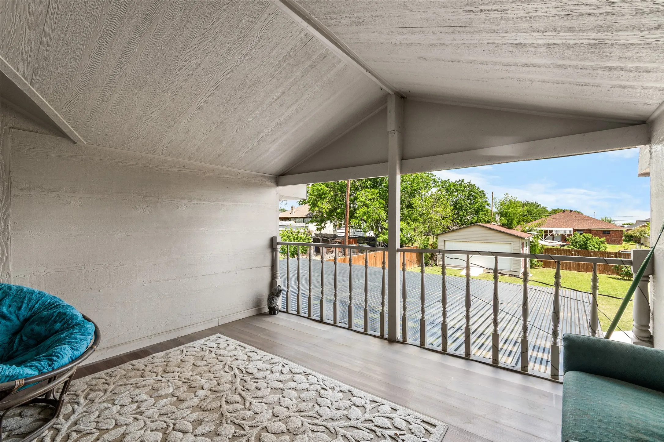 Covered balcony featuring wood-finish flooring, a wood-paneled ceiling, and a painted wood railing