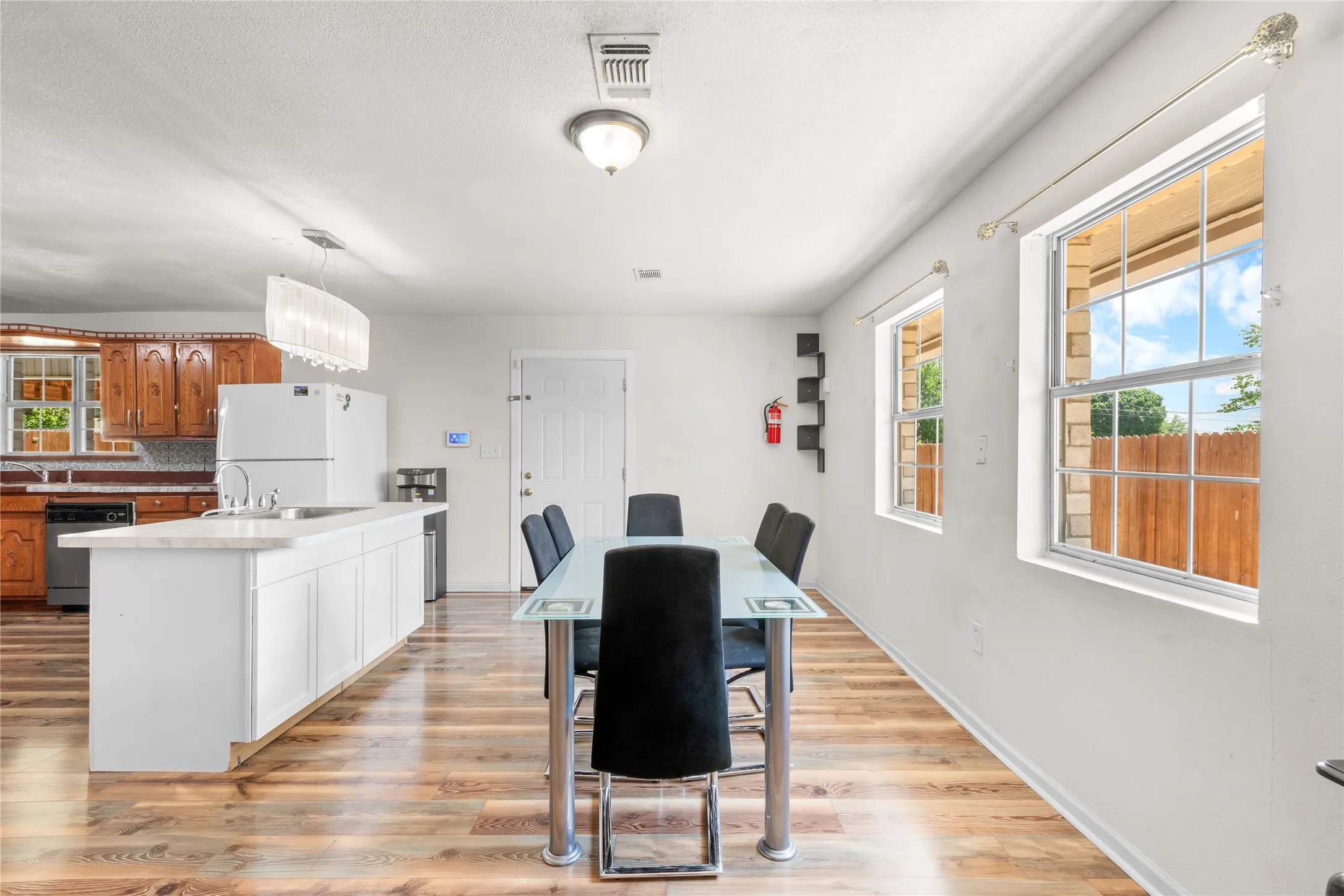 Open-concept dining and kitchen area with wood-finish flooring