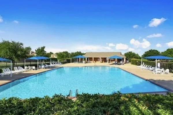 Expansive outdoor Community pool with integrated steps, surrounded by a concrete deck