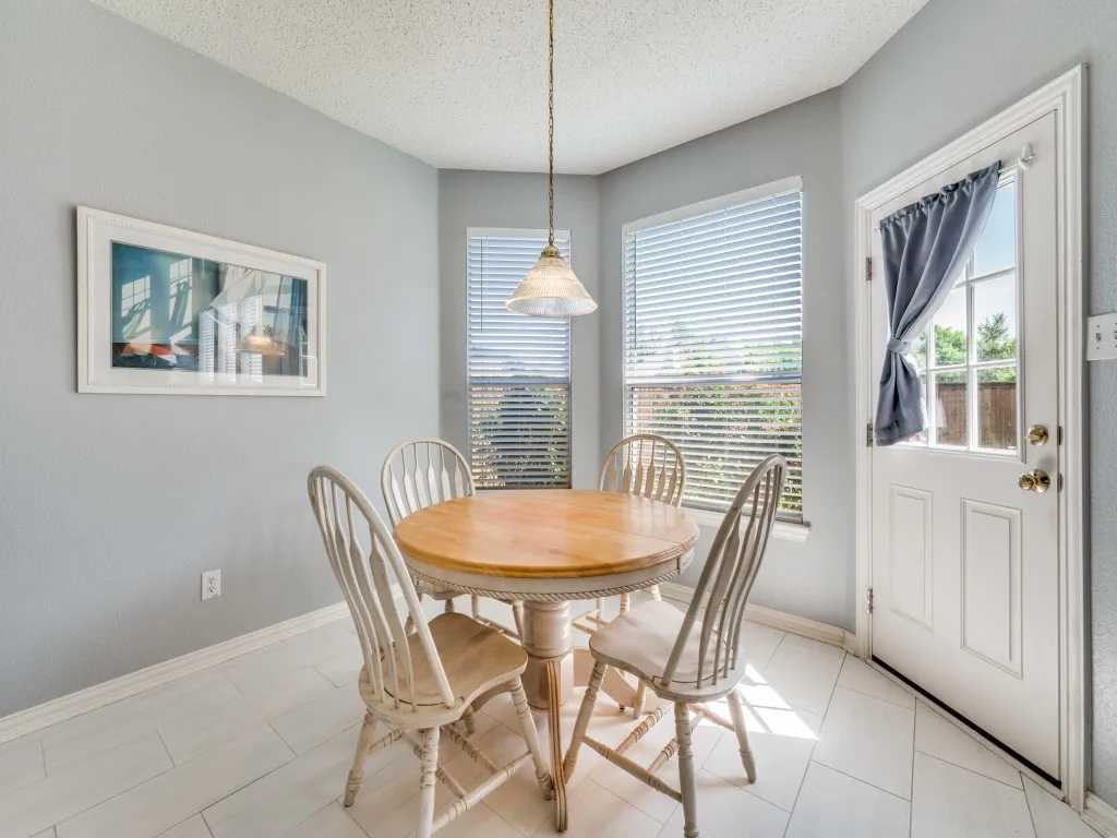 Corner dining area in Kitchen featuring light gray walls and plank-style tile flooring
