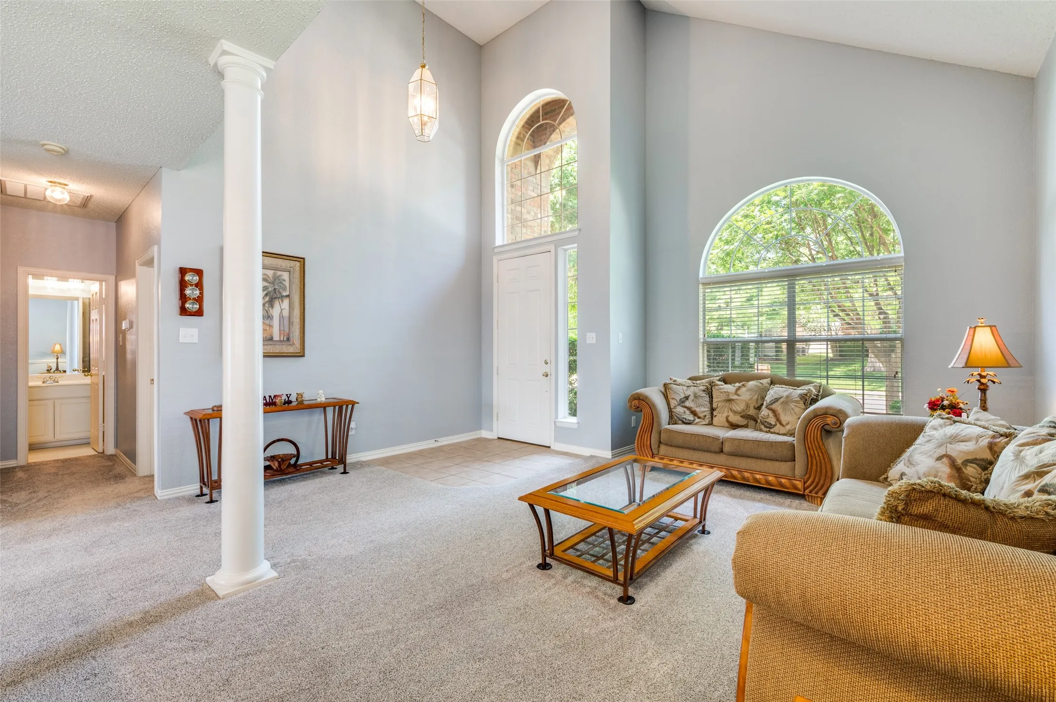 Vaulted ceilings, arched windows, and a decorative column enhance this living space