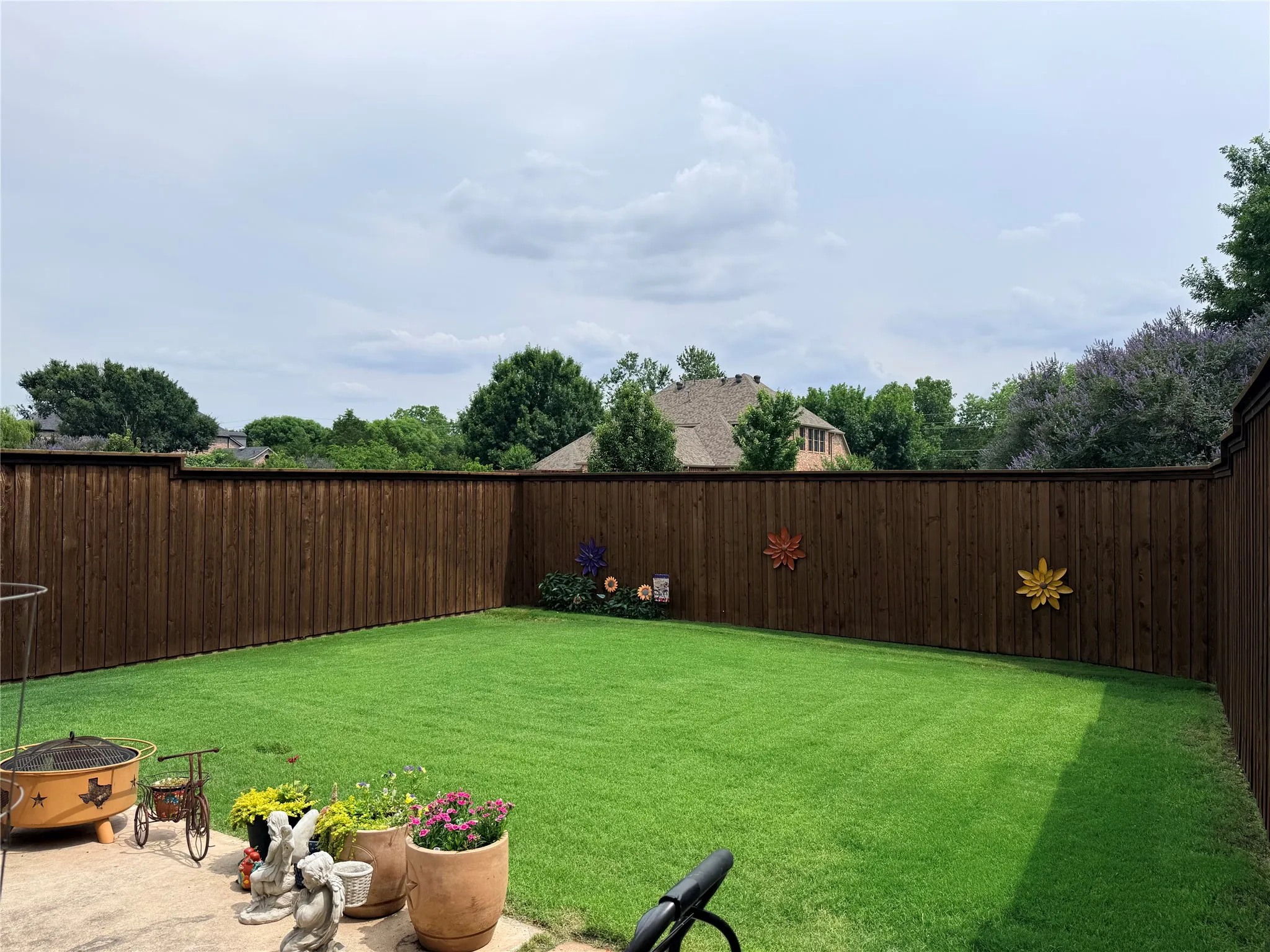 Private backyard featuring a well-maintained lawn and perimeter 8 ft wood fencing