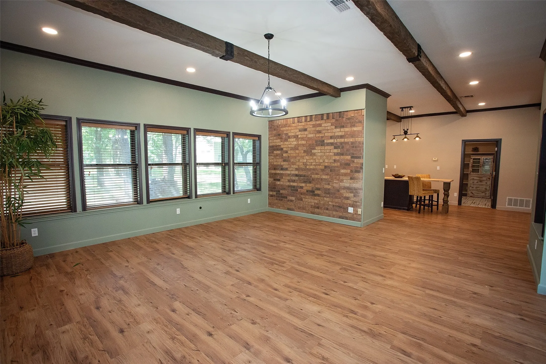 VIEW from the Glass doors off the covered patio: Bright, window-lined space filled with natural light and direct access to the covered front patio through sliding glass doors. Open to the kitchen, this versatile area offers flexibility for a dining room, second living area, or family room, all while taking advantage of the expansive windows and inviting layout.