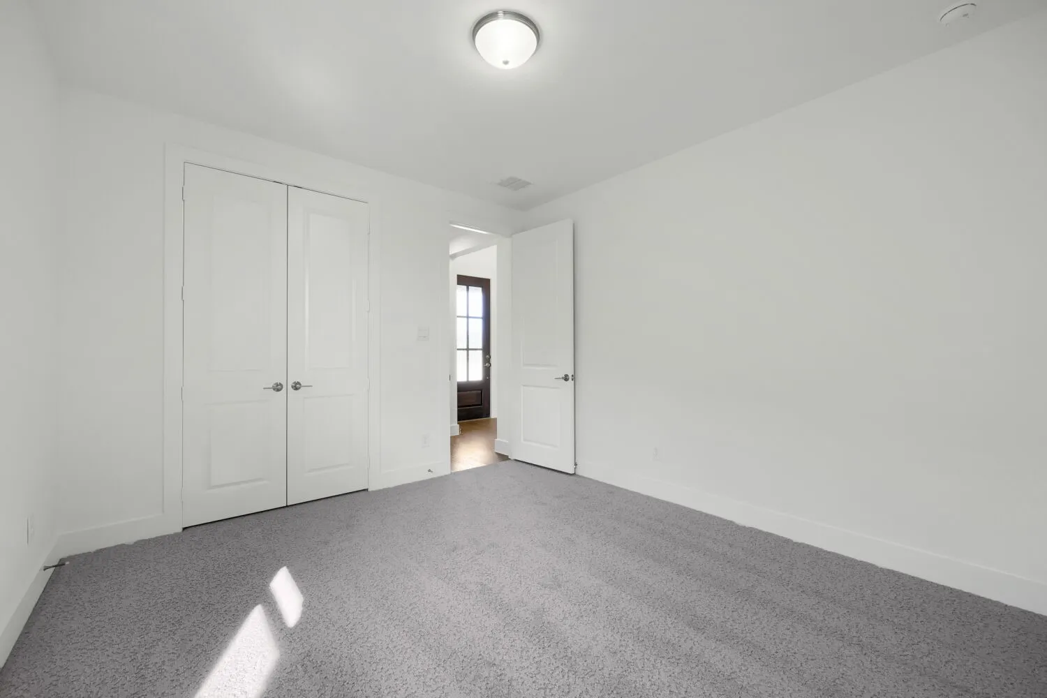 Neutral color palette with light gray carpeting, white walls, and white trim
